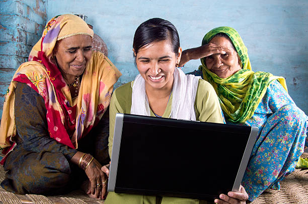 rural chica sosteniendo portátil con los mayores - women poverty senior adult mature adult fotografías e imágenes de stock