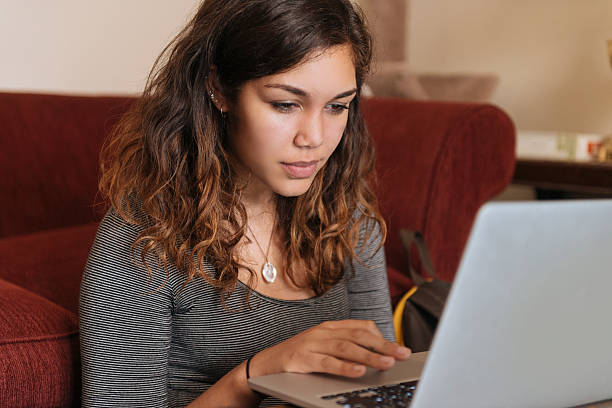 mujer joven estudios en computadora en su casa para la educación superior - puertorriqueño fotografías e imágenes de stock