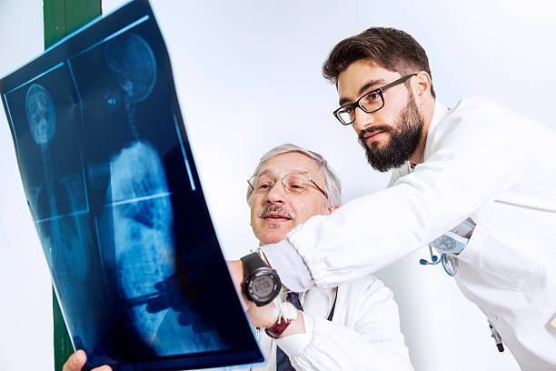 istock doctors examining an X-ray of a woman's body 494056234