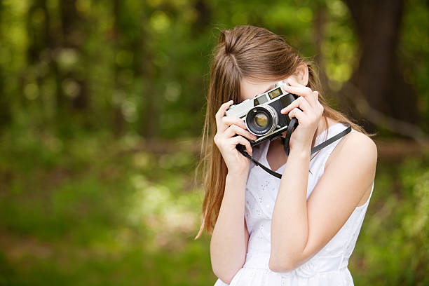 istock Young Girl Taking Photos Outdoors With Vintage Camera 494056285
