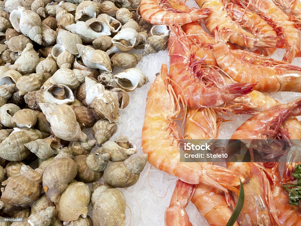 Shrimps And Cockles Display of shrimps at a well supplied fish shop, tossed on ground ice Animal Shell Stock Photo