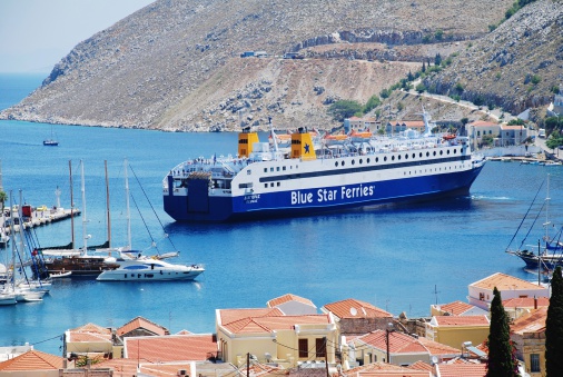 Symi, Greece - June 18, 2011: Blue Star Ferries ship Diagoras docks in Yialos harbour on the Greek island of Symi. The 141mtr ship was built in 1990.