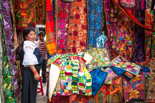 Otavalo, Ecuador - August 4, 2012: Ecuadorian Indian ethnic women in national clothes sells the products of his weaving, as usual on weekdays on a market in the Otavalo