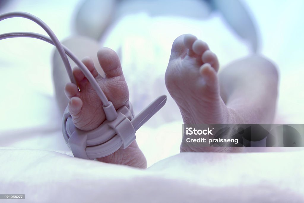 Feet of new born baby under ultraviolet lamp Feet of new born baby under ultraviolet lamp in the incubator Baby - Human Age Stock Photo