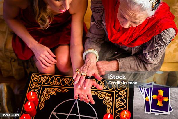 Soothsayer During A Session Doing Palmistry Stock Photo - Download Image Now - Fortune Telling, Fortune Teller, Palmistry Hand