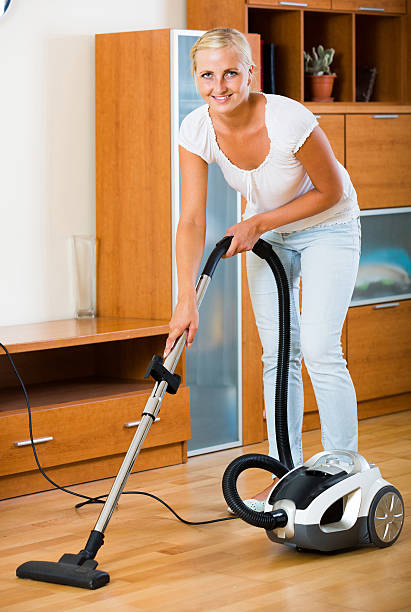 istock blonde in casual using domestic vacuum during clean-up 494062952