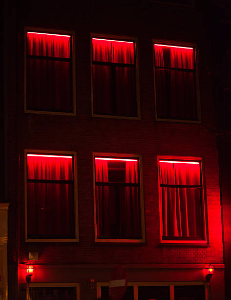 Windows in red light district Wallen Windows with red lights in red light district Wallen in Amsterdam at night. Building at Achterburgwal. wellen stock pictures, royalty-free photos & images