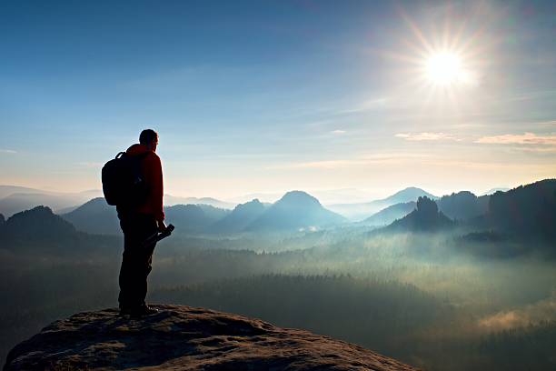 istock Alone  photographer with backpack and tripod  on rocky cliff 494063368