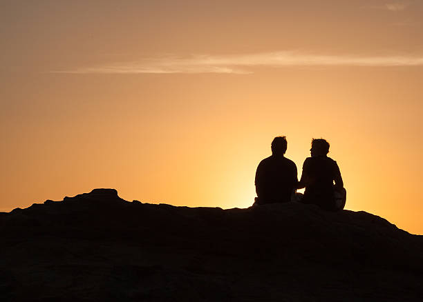 istock Silhouette of Couple sitting at sunset 494064704