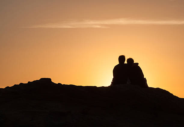 istock Silhouette of Couple sitting at sunset 494064784