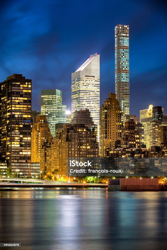 Midtown Manhattan Skyscrapers and East River after Sunset, New York Illuminated Midtown Manhattan skyscrapers and city lights are reflected in East River at twilight. New York City 2015 Stock Photo