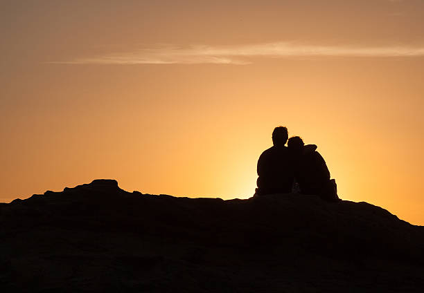istock Silhouette of Couple sitting at sunset 494065026
