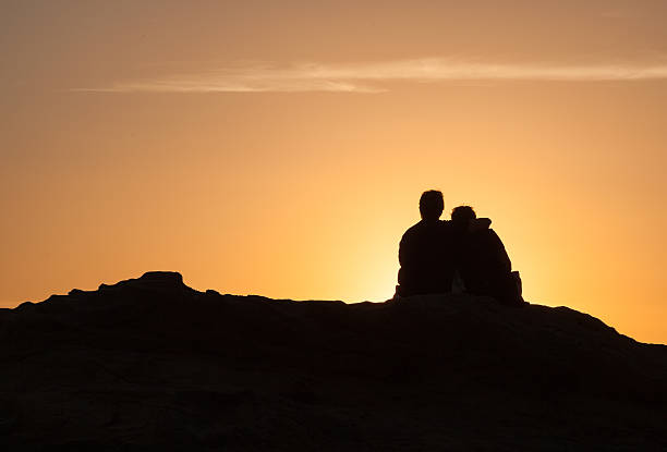 istock Silhouette of Couple sitting at sunset 494065410