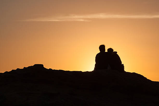 istock Silhouette of Couple sitting at sunset 494065562
