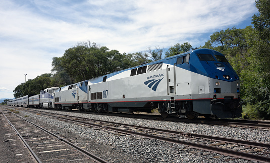 Lamy, United States - September 8, 2015:The eastbound Amtrak Southwest Chief passenger train at Lamy, New Mexico, USA. The train has travelled overnight from Los Angeles and is heading for Chicago. The train is powered by a pair of GE P42DC, numbers 187 and 198, and a single EMD F59PHI locomotive, number 455, all diesels. This train, and its westbound counterpart, are the only two trains to traverse this route per day as it has no freight service. Unidentified crew.