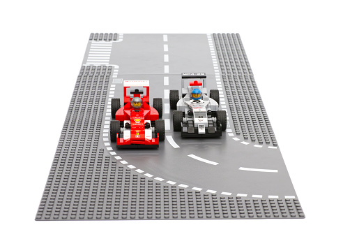 Tambov, Russian Federation - June 27, 2015: Lego Ferrari F14 T and McLaren Mercedes race cars by LEGO Speed Champions on Lego road baseplates. White background. Studio shot.
