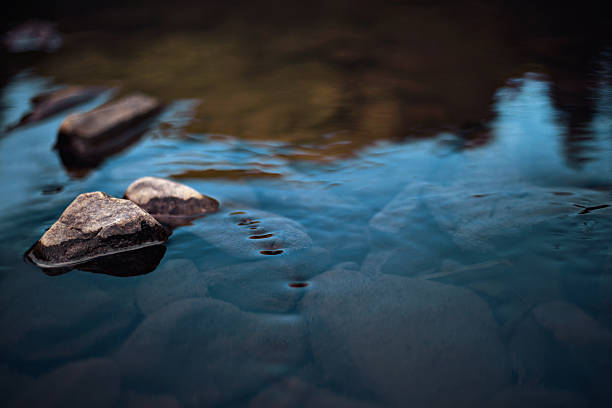 Rocks in slow rinnig stream Rocks in stream with smooth flowing water river stock pictures, royalty-free photos & images