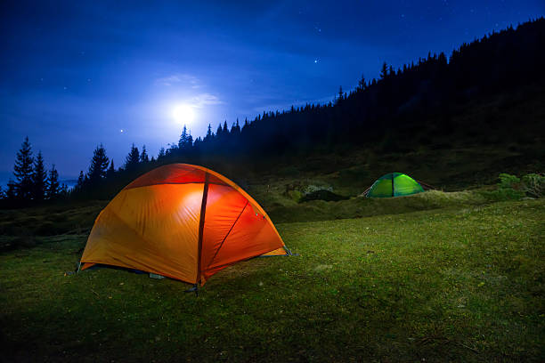 istock Two Illuminated orange and green camping tents 494067448
