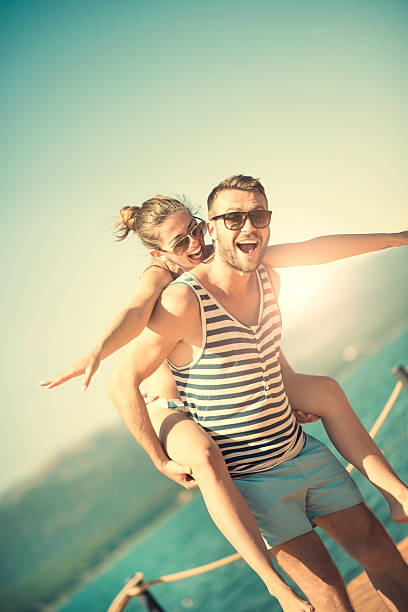 istock Attractive Couple Having Fun with Piggyback Ride at the beach 494068276