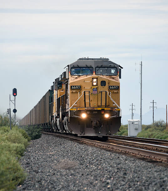 Wilcox, United States - September 5, 2015: A Union Pacific freight train heads east on a twin track section of the former Southern Pacific route between Tucson, Arizona and El Paso, Texas. The location is St Simon in Cochise County, Arizona which is 64 kilometres east of Wilcox. The train consists of open wagons with three locomotives leading and two at the rear assisting. The lead locomotive is 6697 with 7147 and 6224 following, all General Electric AC44W diesels. Unidentified train crew.