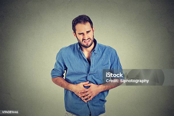 Junger Mann Mit Bauch Schmerzen Magenverstimmung Stockfoto und mehr Bilder von Reizdarmsyndrom - Reizdarmsyndrom, Diarrhö, Blau