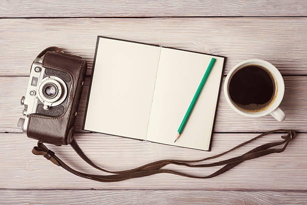 istock Old camera with open notebook and cup of coffee 494084850