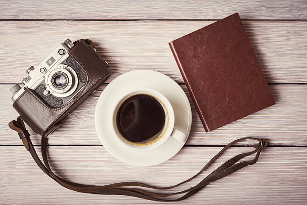 istock Vintage camera, notebook and cup of coffee over wooden desk 494085270
