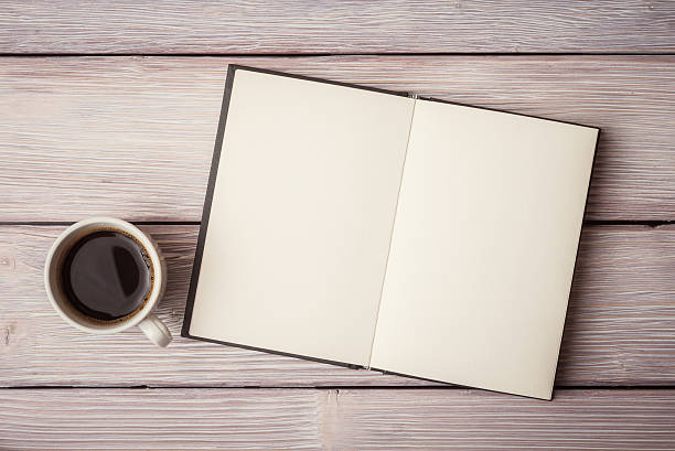 istock Open notebook with cup of coffee on wooden desk 494086220