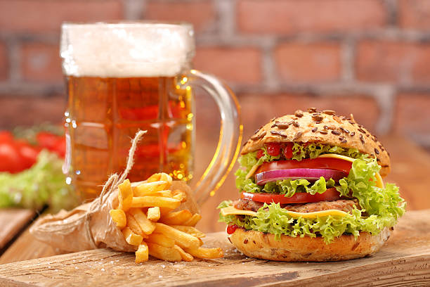 istock Grilled hamburger with fries and beer on brick wall background 494089604