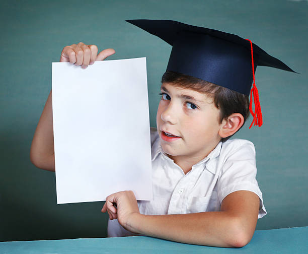 istock boy in graduation cap whith white paper sheet 494092026