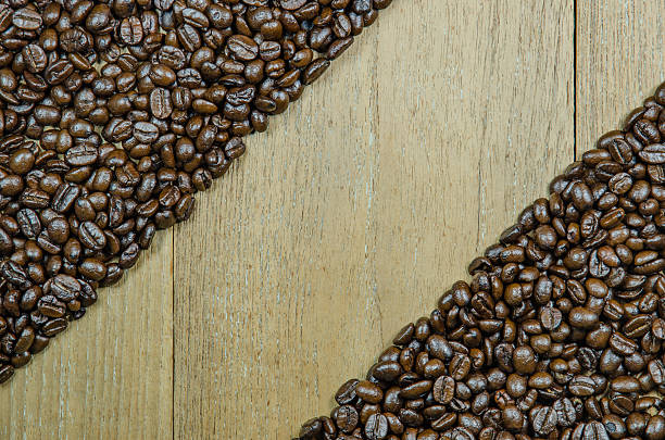 roasted grãos de café sobre fundo de madeira - coffeetree - fotografias e filmes do acervo