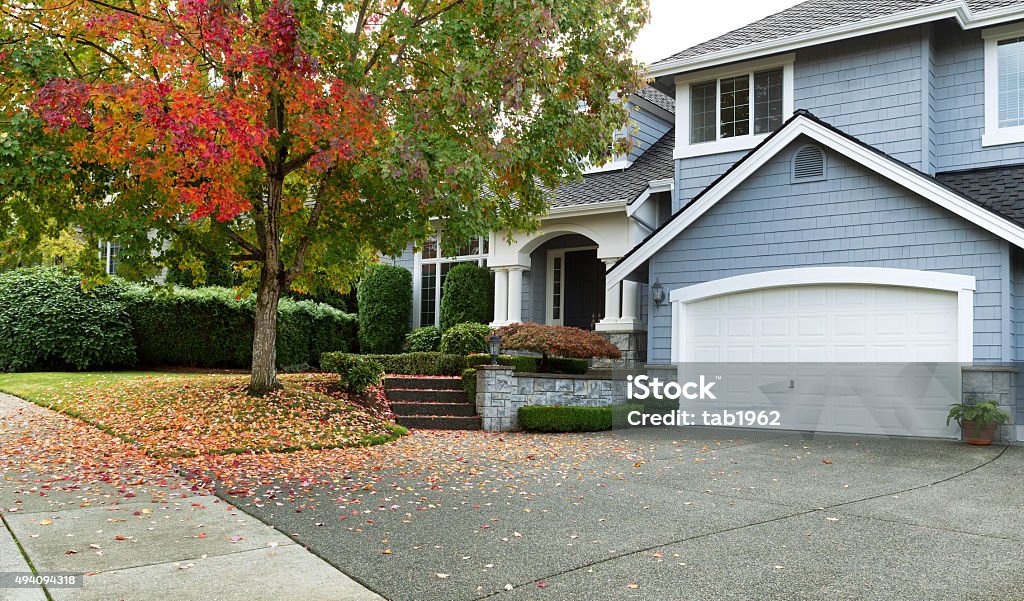 Early autumn with modern residential single family home Driveway to front walkway view of partial front of residential home during early autumn season. House Stock Photo