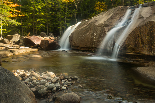 Waterfalls of Lucy Brook cascade over granite wall into plunge pool at Diana's Baths in Bartlett, New Hampshire.