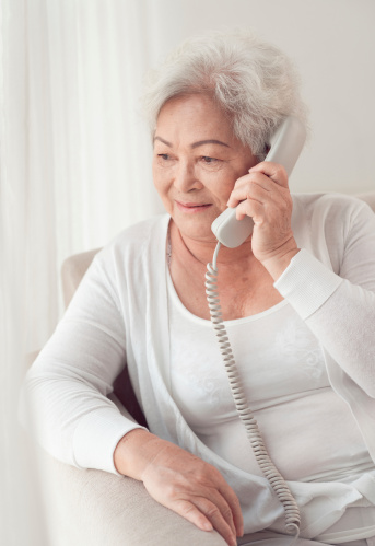 Aged Asian woman talking on the phone