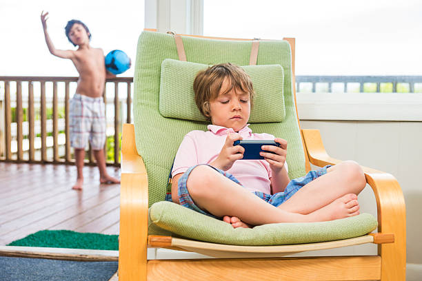 Photo of cute schoolboy scream play games controller wear t-shirt modern interior apartment indoors.