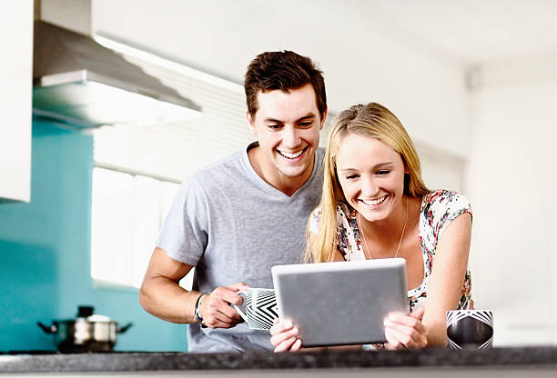 istock Smiling young couple looking at digital tablet screen 494118311