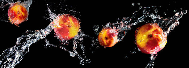 pesca in acqua splash su sfondo nero, messa a fuoco differenziale - peach nectarine wet drop foto e immagini stock