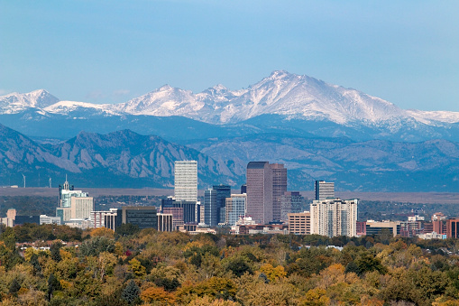 With the snow covered Longs Peak part of the Rocky Mountains and the iconic flatirons of Boulder in the background, Downtown Denver skyscrapers including the iconic 