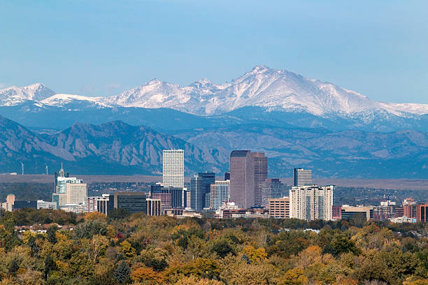 Snowy Longs Peak and Downtown Denver Colorado skyscrapers With the snow covered Longs Peak part of the Rocky Mountains and the iconic flatirons of Boulder in the background, Downtown Denver skyscrapers including the iconic "mailbox" or "cash register" building as well as hotels, office buildings and apartment buildings fill the skyline. colorado photos stock pictures, royalty-free photos & images