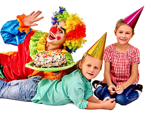 istock Clown holding cake on birthday with group children 494119512