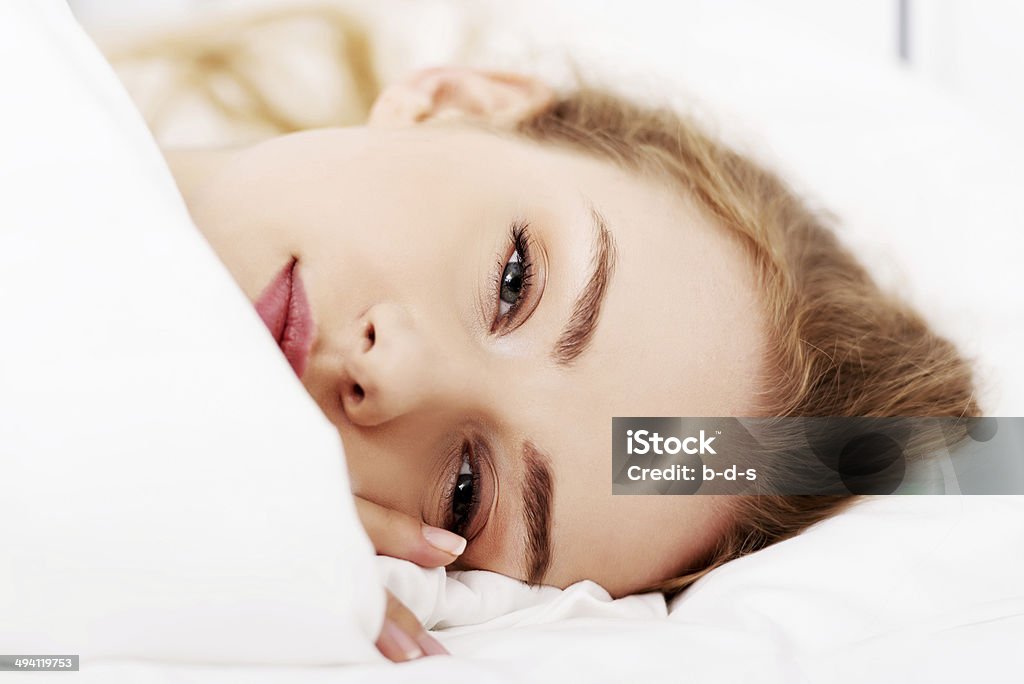 Beautiful caucasian woman lying in bed Beautiful caucasian woman lying in bed over white Adult Stock Photo