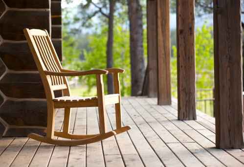 A rocking chair on a wood deck.