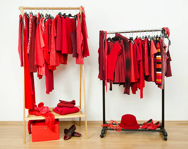 Wardrobe with red clothes hanging on a rack nicely arranged. stock photo