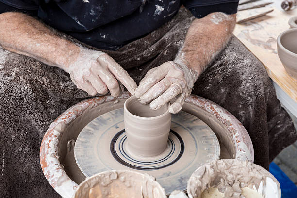 istock Potter Smoothing Edges of a Clay Jar 494120866