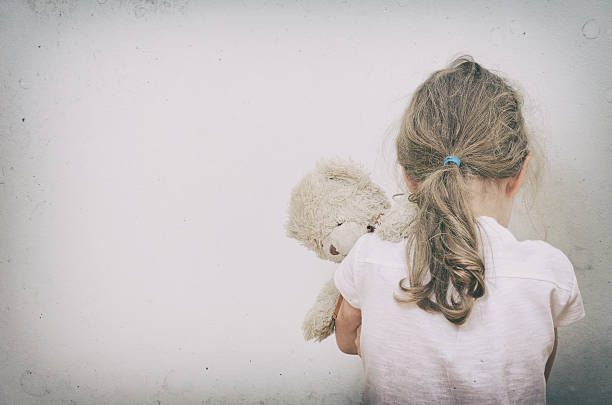 Little girl crying in the corner. stock photo