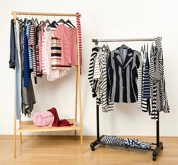 istock Dressing closet with striped clothes arranged on hangers. 494121631