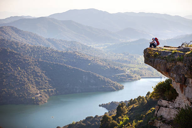 istock Female hiker sitting on cliff and enjoying valley view 494122051