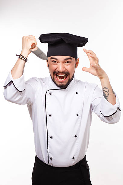 istock handsome cook in uniform and hat gesturing with  big  knife 494122242