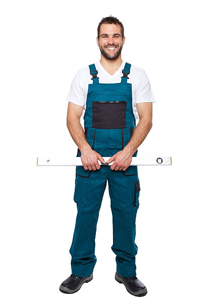 trabalhador sorridente em uniforme verde com nível - protective workwear bricklayer manual worker construction imagens e fotografias de stock