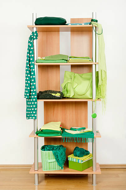 istock Green clothes nicely arranged on a shelf. 494125513
